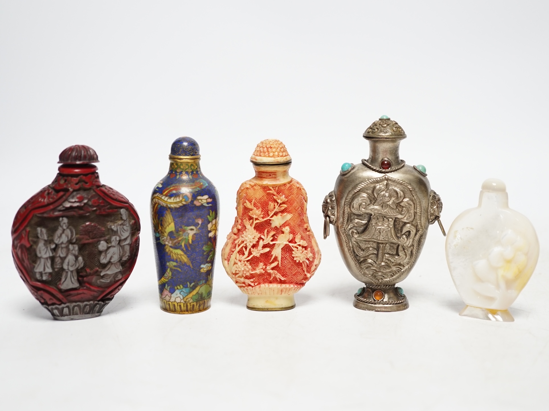 A Chinese cloisonné enamel snuff bottle, two resin snuff bottles, a carved mother of pearl snuff bottle and a Tibetan style metal snuff bottle, largest 8.5cm high